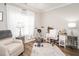 Bright bedroom with a cream chair, desk, stationary bike and wood flooring at 2413 Whelen Dr, Graham, NC 27253