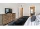 Comfortable bedroom featuring a TV, wooden dresser, and doorway leading to an ensuite bathroom and closet at 2413 Whelen Dr, Graham, NC 27253