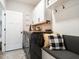 Functional laundry room with built-in bench, white cabinets, wood countertop, and modern appliances at 2413 Whelen Dr, Graham, NC 27253