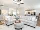 Spacious living room with large sectional, ottoman, and open view to the kitchen with white cabinetry at 2413 Whelen Dr, Graham, NC 27253