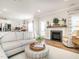 Bright, open-concept living room featuring stylish furniture and a view into the dining room and kitchen at 2413 Whelen Dr, Graham, NC 27253