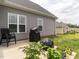 Back patio featuring gray siding, outdoor seating, and a small garden, perfect for relaxing or entertaining at 2413 Whelen Dr, Graham, NC 27253