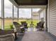 Inviting screened porch with wicker furniture, offering a cozy outdoor living space and neighborhood views at 2413 Whelen Dr, Graham, NC 27253