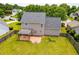Aerial view of a fenced backyard with patio, fire pit, and a well-maintained lawn at 2419 Pepperstone Dr, Graham, NC 27253
