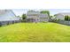 A spacious backyard with lush green grass, wooden fence, patio area, and fire pit perfect for outdoor activities at 2419 Pepperstone Dr, Graham, NC 27253