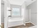 Relaxing bathroom with soaking tub, glass block window, and a separate shower stall at 2419 Pepperstone Dr, Graham, NC 27253