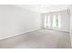 Bright bedroom with plush carpet, two windows with sheer curtains, and neutral wall color at 2419 Pepperstone Dr, Graham, NC 27253