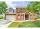 Charming two-story brick home with an attached garage and well-manicured lawn on a sunny day at 2419 Pepperstone Dr, Graham, NC 27253