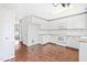 Bright kitchen featuring granite countertops, white cabinetry, and hardwood floors for a modern, clean look at 2419 Pepperstone Dr, Graham, NC 27253