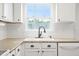 Sunlit kitchen featuring white cabinets, granite countertops, subway tile backsplash, and a modern faucet at 2419 Pepperstone Dr, Graham, NC 27253