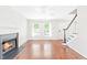 Bright living room features hardwood floors, a fireplace, and large windows offering plenty of natural light at 2419 Pepperstone Dr, Graham, NC 27253