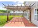 Backyard patio with brick flooring, wooden pergola, and ceiling fan for outdoor relaxation and entertainment at 2419 Pepperstone Dr, Graham, NC 27253