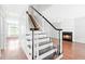 Elegant staircase with black and white accents, leading to an upper level with a cozy fireplace at 2419 Pepperstone Dr, Graham, NC 27253