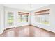 Bright sunroom with multiple windows, hardwood floors, and a door leading to the outside at 2419 Pepperstone Dr, Graham, NC 27253