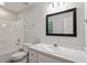 Bathroom features a shower-tub combination with white fixtures and a large mirror at 2474 Sumter Dr, Garner, NC 27529