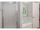 Bright bathroom features a frosted glass shower stall and a large soaking tub beneath a window at 2474 Sumter Dr, Garner, NC 27529