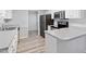 Modern kitchen with white cabinets and appliances with views to the dining area at 2474 Sumter Dr, Garner, NC 27529