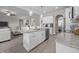 Open concept kitchen with stainless steel appliances, granite counters, island, and view into living area at 31 Sweet Birch Ave, Zebulon, NC 27597