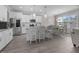 Bright kitchen with white cabinets, granite countertops, stainless steel appliances, island, and adjacent dining area at 31 Sweet Birch Ave, Zebulon, NC 27597