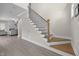 Elegant staircase featuring wood treads, white risers, and a stylish black iron railing, with open floor plan at 31 Sweet Birch Ave, Zebulon, NC 27597