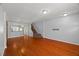 Open-concept living space with gleaming hardwood floors and staircase access at 3100 Berkeley Springs Pl, Raleigh, NC 27616