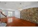 View of the spacious living area featuring hardwood floors and a stone accent wall at 3100 Berkeley Springs Pl, Raleigh, NC 27616