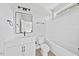 White bathroom with tub and shower combo, white vanity, wood look flooring and window at 317 W Murray Ave, Durham, NC 27704