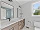 Bathroom with double vanity sinks, dark wood cabinets, white countertops and a tiled shower at 317 W Murray Ave, Durham, NC 27704