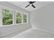 Bedroom with many windows overlooking trees and nature, ceiling fan at 317 W Murray Ave, Durham, NC 27704