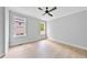 An empty bedroom with wood flooring featuring a ceiling fan and two windows at 317 W Murray Ave, Durham, NC 27704