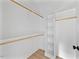 Walk-in closet with custom shelving, hanging rods and laminate wood flooring at 317 W Murray Ave, Durham, NC 27704