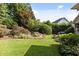 Lush backyard featuring a well-manicured lawn, mature trees, and a charming water feature at 3311 Canoe Brook Pkwy, Raleigh, NC 27614