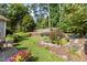 Escape to your own private garden with lush landscaping, meandering walkways, and rock features at 3311 Canoe Brook Pkwy, Raleigh, NC 27614