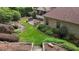 Expansive backyard with a stone patio, outdoor grill, lush lawn, tranquil pond, and mature landscaping at 3311 Canoe Brook Pkwy, Raleigh, NC 27614