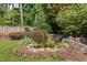 Scenic backyard with a tranquil waterfall feature surrounded by lush greenery and flowers at 3311 Canoe Brook Pkwy, Raleigh, NC 27614