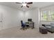 Bedroom area featuring neutral walls and carpet, a ceiling fan, window, and an office area with desk and chair at 3311 Canoe Brook Pkwy, Raleigh, NC 27614