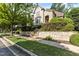 Elegant home featuring a light brick facade, lush landscaping, and a retaining wall at 3311 Canoe Brook Pkwy, Raleigh, NC 27614