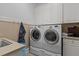 Well-equipped laundry room with front-loading washer and dryer, and ample storage cabinets above at 3311 Canoe Brook Pkwy, Raleigh, NC 27614