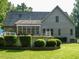 Home's back exterior featuring a patio area, retractable awning, and views of the lush green lawn at 334 Dell Meadows Pl, Four Oaks, NC 27524