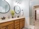 Bathroom featuring double sinks with bronze fixtures and an adjoining closet at 334 Dell Meadows Pl, Four Oaks, NC 27524