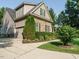 Charming two-story home with stone accents, green shutters, well-manicured landscaping, and attached garage at 334 Dell Meadows Pl, Four Oaks, NC 27524