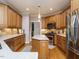 Bright kitchen with stainless steel appliances, wood floors, and island with granite countertops at 334 Dell Meadows Pl, Four Oaks, NC 27524