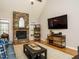 Bright living room with a stone fireplace, hardwood floors, and modern entertainment setup at 334 Dell Meadows Pl, Four Oaks, NC 27524