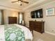 Relaxing main bedroom featuring dark wood furniture, tray ceiling, and bright windows at 334 Dell Meadows Pl, Four Oaks, NC 27524