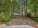 Peaceful backyard view showcasing mature trees and partial view of the home from the deck at 3811 Carnegie Ln, Raleigh, NC 27612