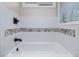 Bathtub with white tiles, stone accent, and a window for natural light at 3811 Carnegie Ln, Raleigh, NC 27612