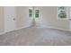 A bright bedroom features plush carpeting, two windows, and a white door at 3811 Carnegie Ln, Raleigh, NC 27612