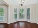 Bright dining area featuring hardwood floors and large windows with natural lighting and white trim at 3811 Carnegie Ln, Raleigh, NC 27612