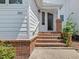 Covered home entrance with brick stairway and front door at 3811 Carnegie Ln, Raleigh, NC 27612