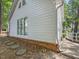 Exterior of home with white siding, brick foundation, large windows, and a driveway at 3811 Carnegie Ln, Raleigh, NC 27612